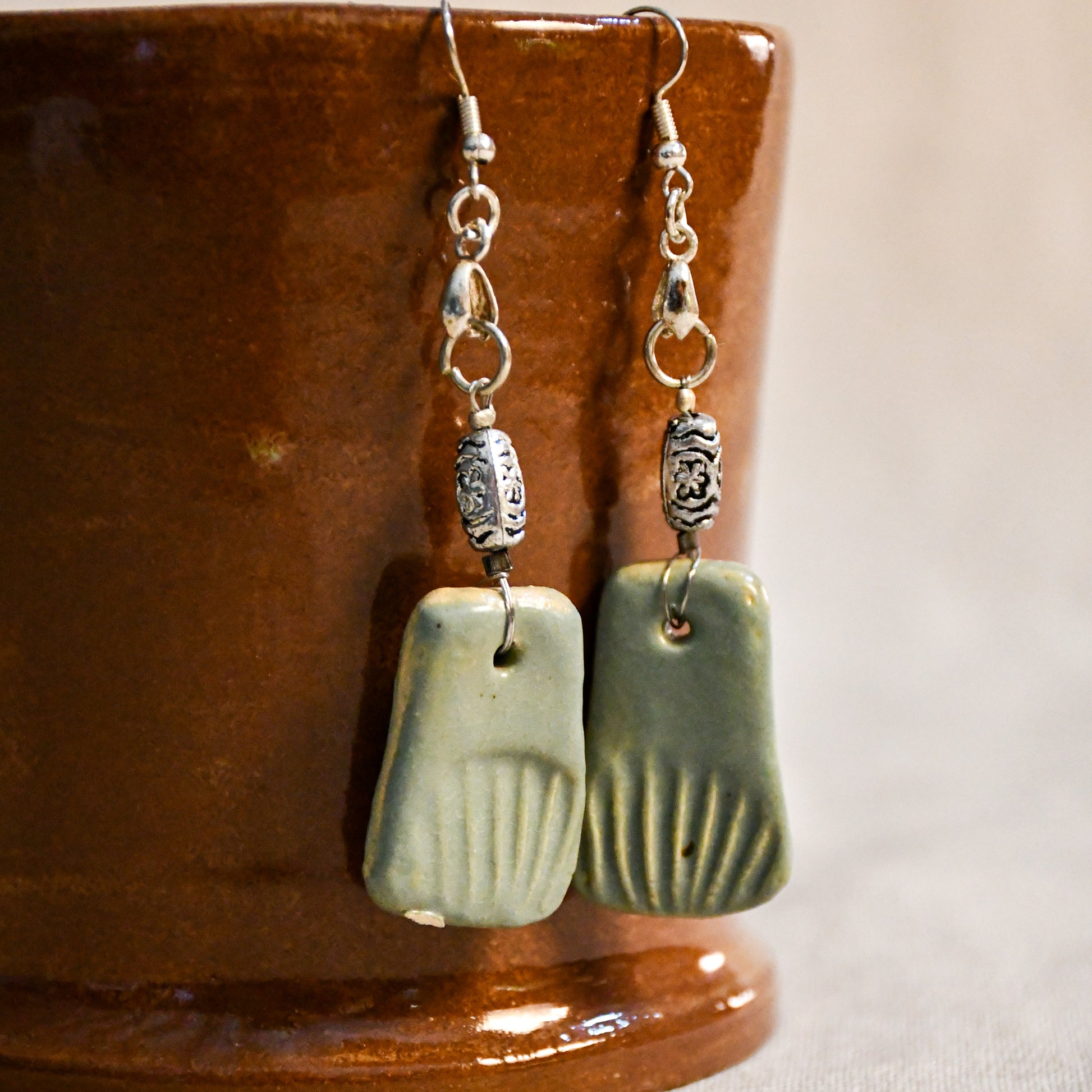 Handmade ceramic dangle earrings by Leigh Art with a modern boho silhouette.