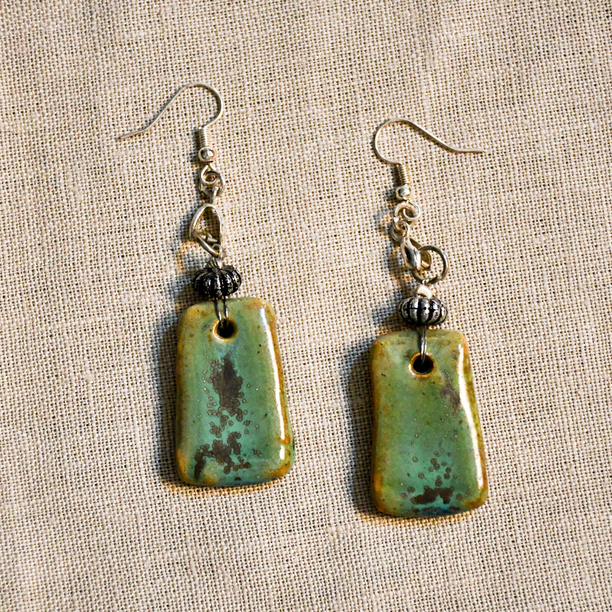 Handmade ceramic dangle earrings by Leigh Art with a modern boho silhouette.