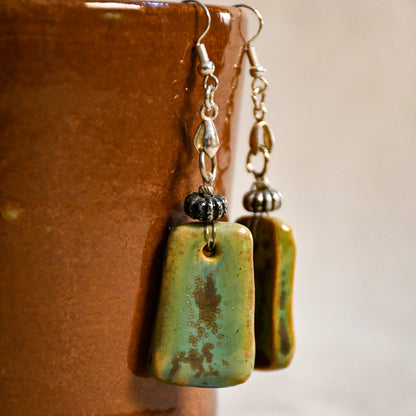 Handmade ceramic dangle earrings by Leigh Art with a modern boho silhouette.
