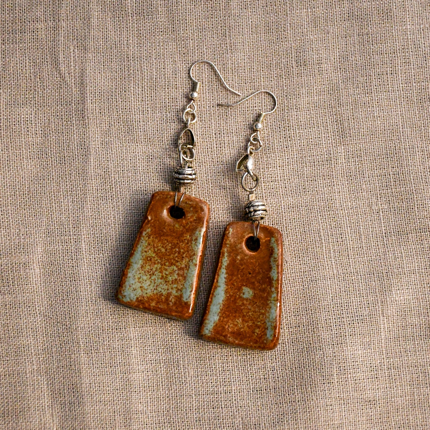Handmade ceramic dangle earrings by Leigh Art with a modern boho silhouette.