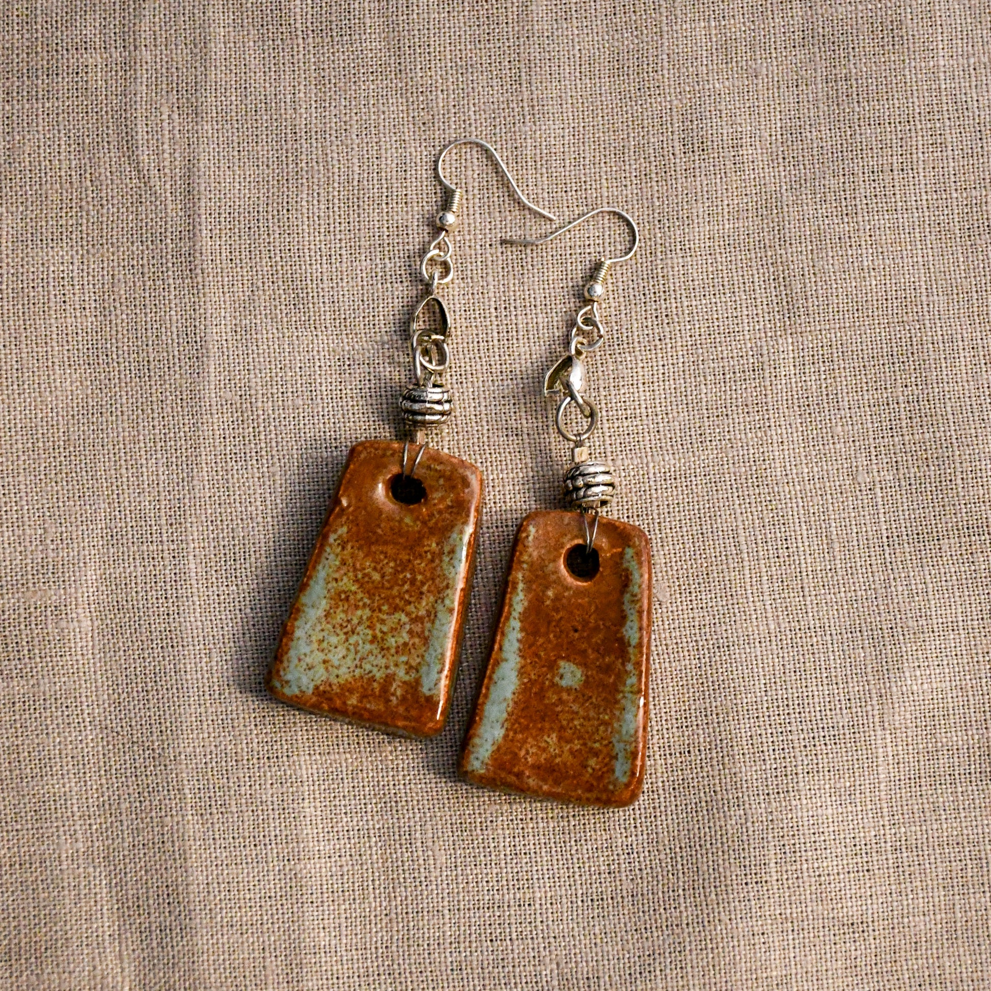 Handmade ceramic dangle earrings by Leigh Art with a modern boho silhouette.