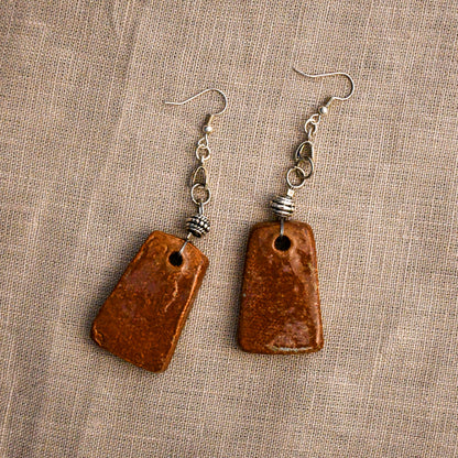 Handmade ceramic dangle earrings by Leigh Art with a modern boho silhouette.