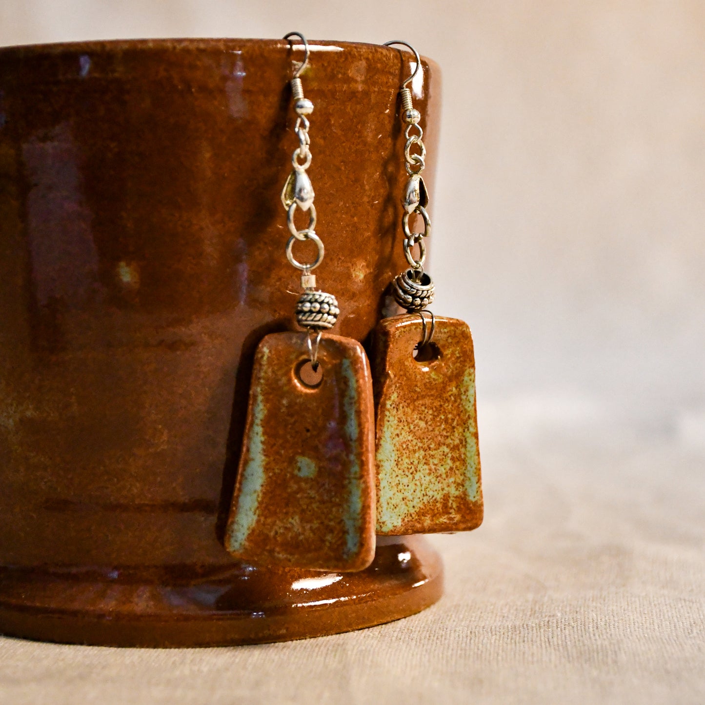 Handmade ceramic dangle earrings by Leigh Art with a modern boho silhouette.