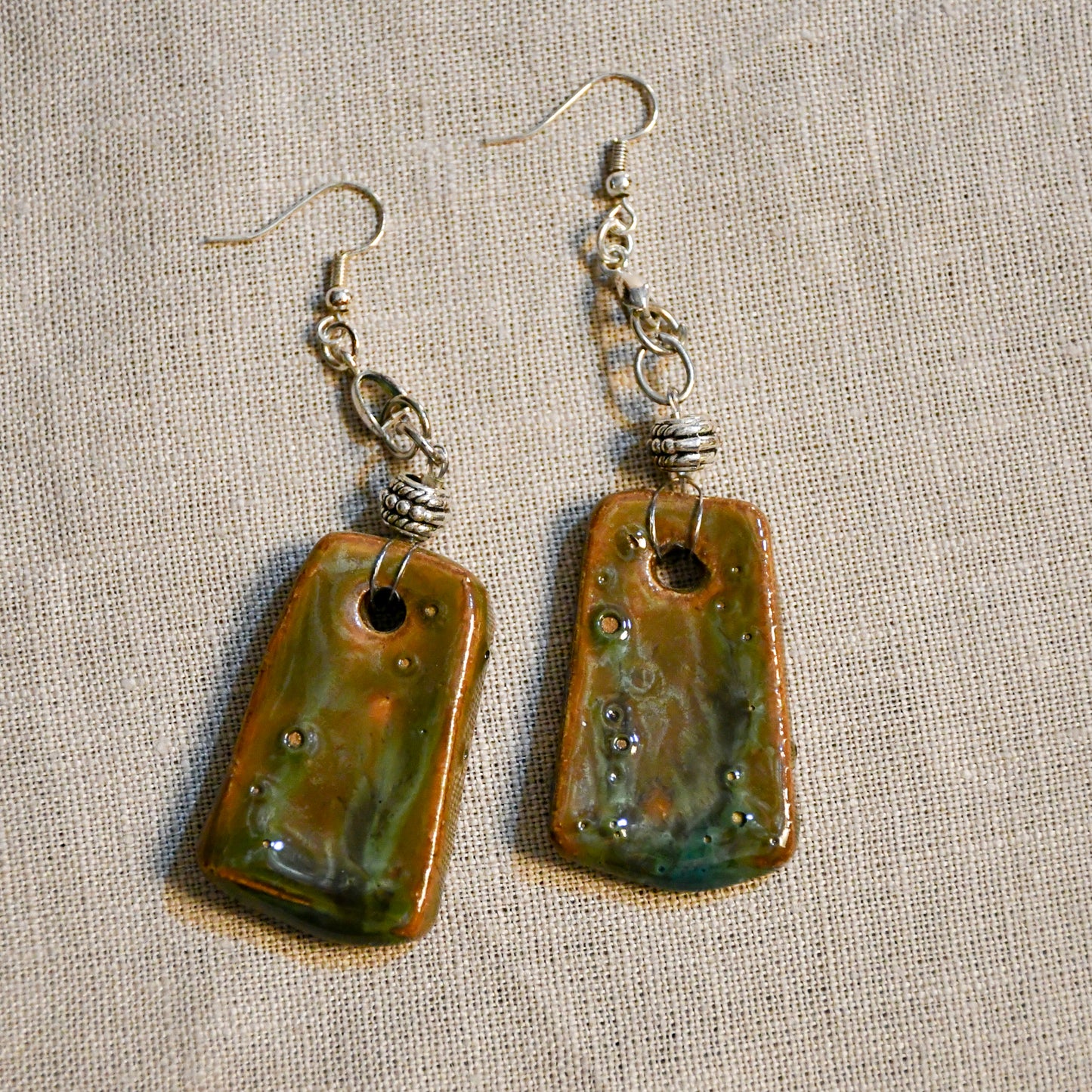 Handmade ceramic dangle earrings by Leigh Art with a modern boho silhouette.