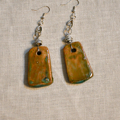 Handmade ceramic dangle earrings by Leigh Art with a modern boho silhouette.