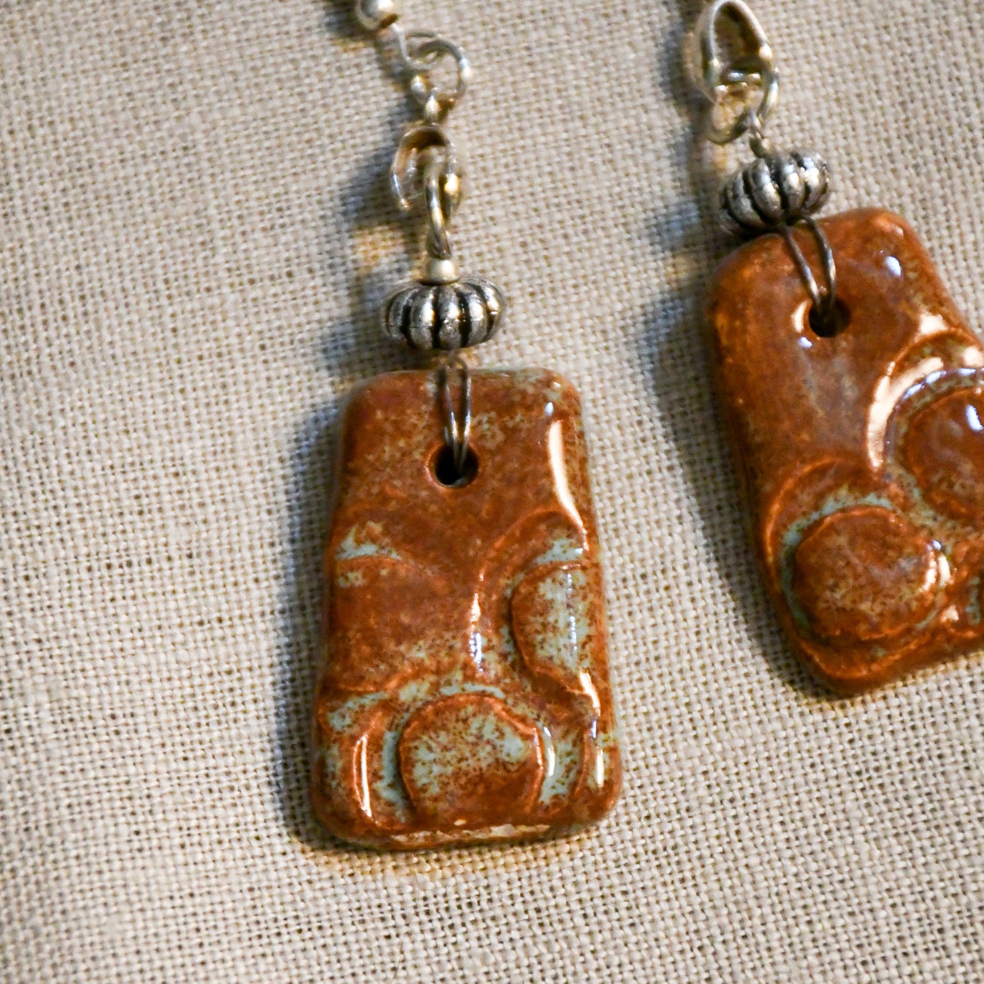 Handmade ceramic stamped dangle earrings by Leigh Art.