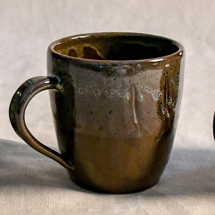 Handmade ceramic mug by Leigh Art featuring Espuela glaze with one-of-a-kind earth-tone movement and wheel-thrown craftsmanship.