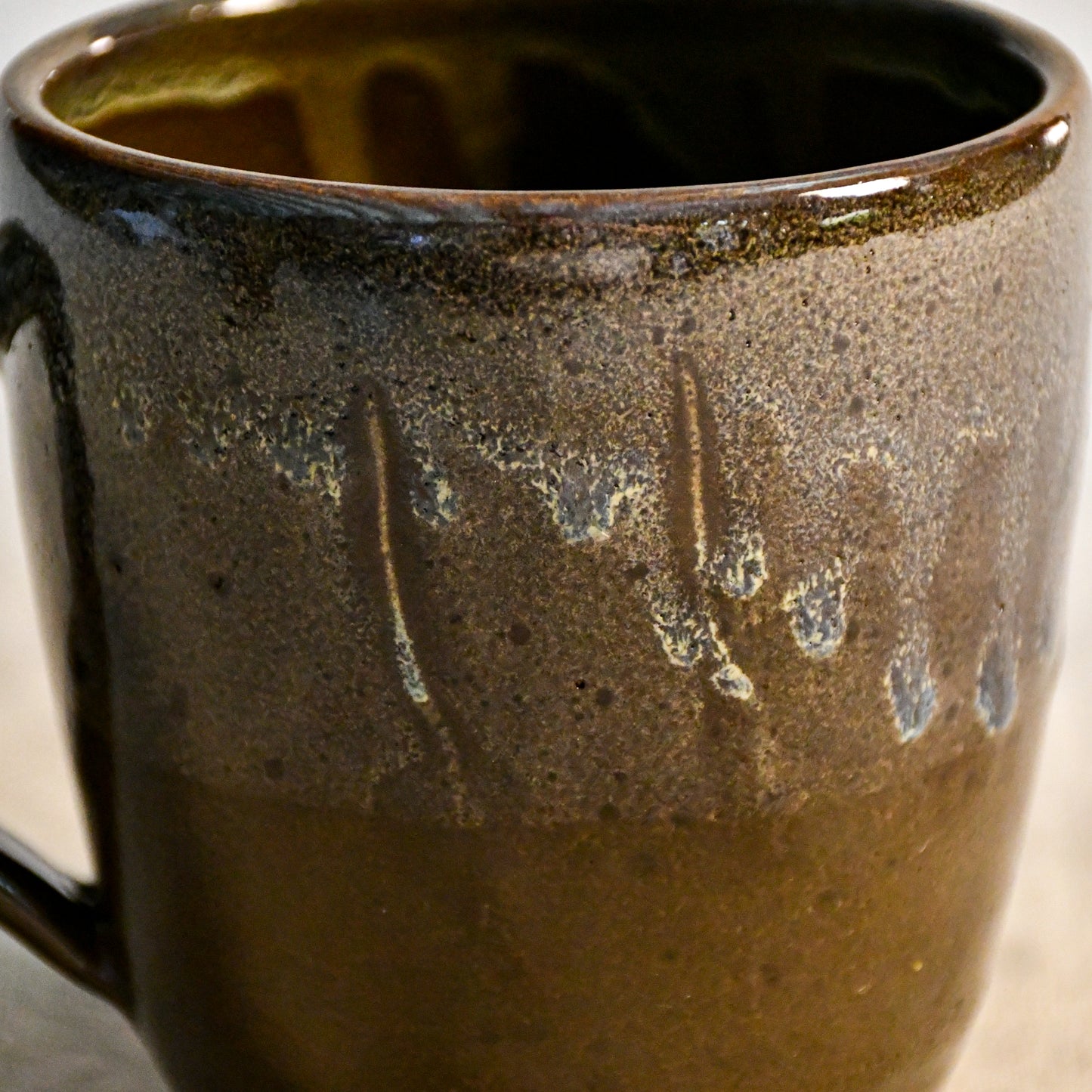 Handmade ceramic mug by Leigh Art featuring Espuela glaze with one-of-a-kind earth-tone movement and wheel-thrown craftsmanship.