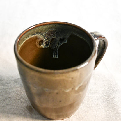 Handmade ceramic mug by Leigh Art featuring Espuela glaze with one-of-a-kind earth-tone movement and wheel-thrown craftsmanship.