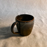 Handmade ceramic mug by Leigh Art featuring Espuela glaze with one-of-a-kind earth-tone movement and wheel-thrown craftsmanship.