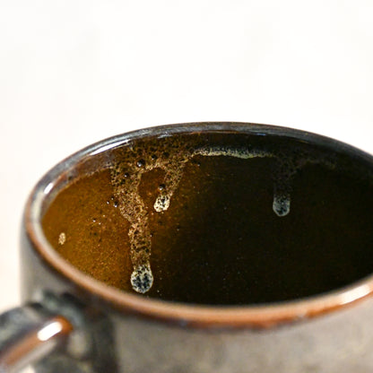 Handmade ceramic mug by Leigh Art featuring Espuela glaze with one-of-a-kind earth-tone movement and wheel-thrown craftsmanship.