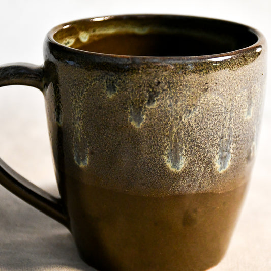 Handmade ceramic mug by Leigh Art featuring Espuela glaze with one-of-a-kind earth-tone movement and wheel-thrown craftsmanship.