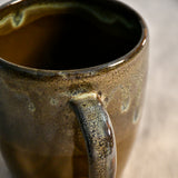 Handmade ceramic mug by Leigh Art featuring Espuela glaze with one-of-a-kind earth-tone movement and wheel-thrown craftsmanship.