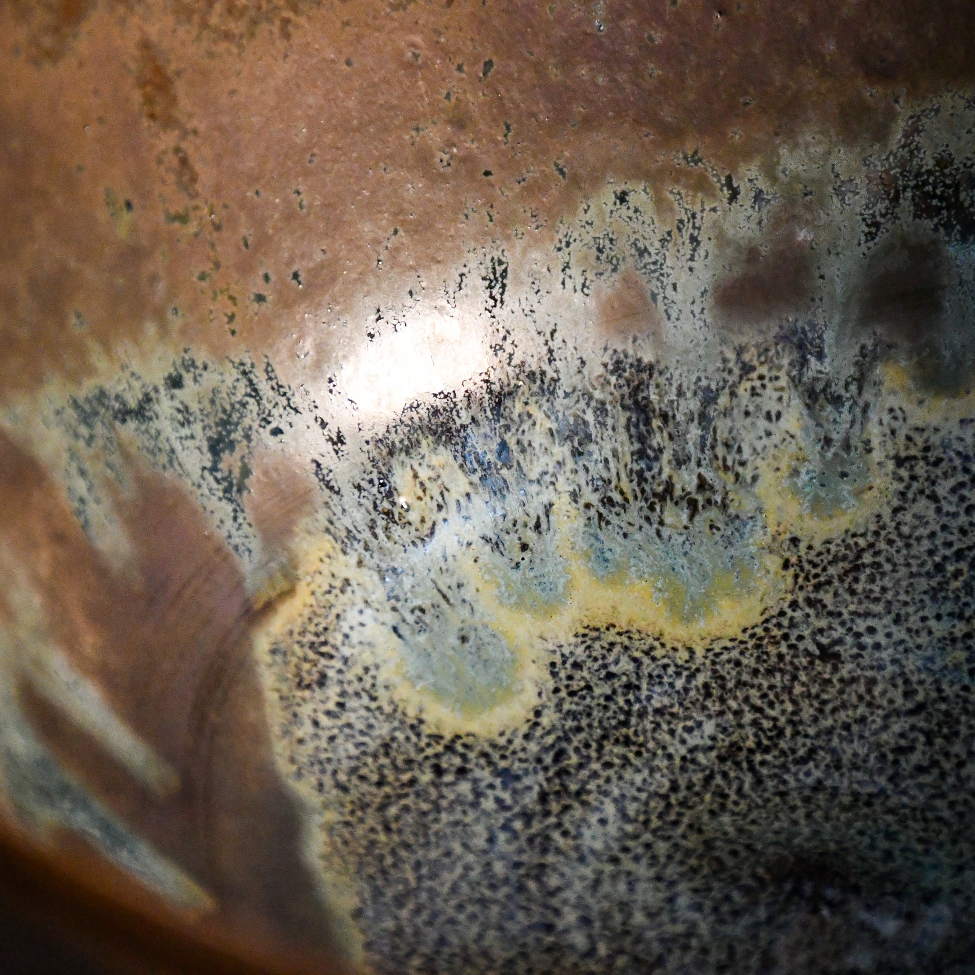 Close-up of the Espuela glaze on a handmade serving bowl, showcasing flowing earth tones and unique kiln effects.