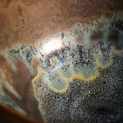 Close-up of the Espuela glaze on a handmade serving bowl, showcasing flowing earth tones and unique kiln effects.