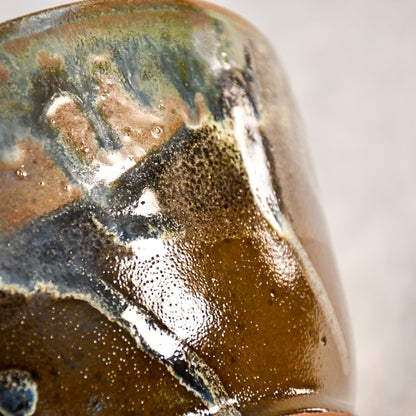Close-up of the Espuela glaze on a handmade serving bowl, showcasing flowing earth tones and unique kiln effects.