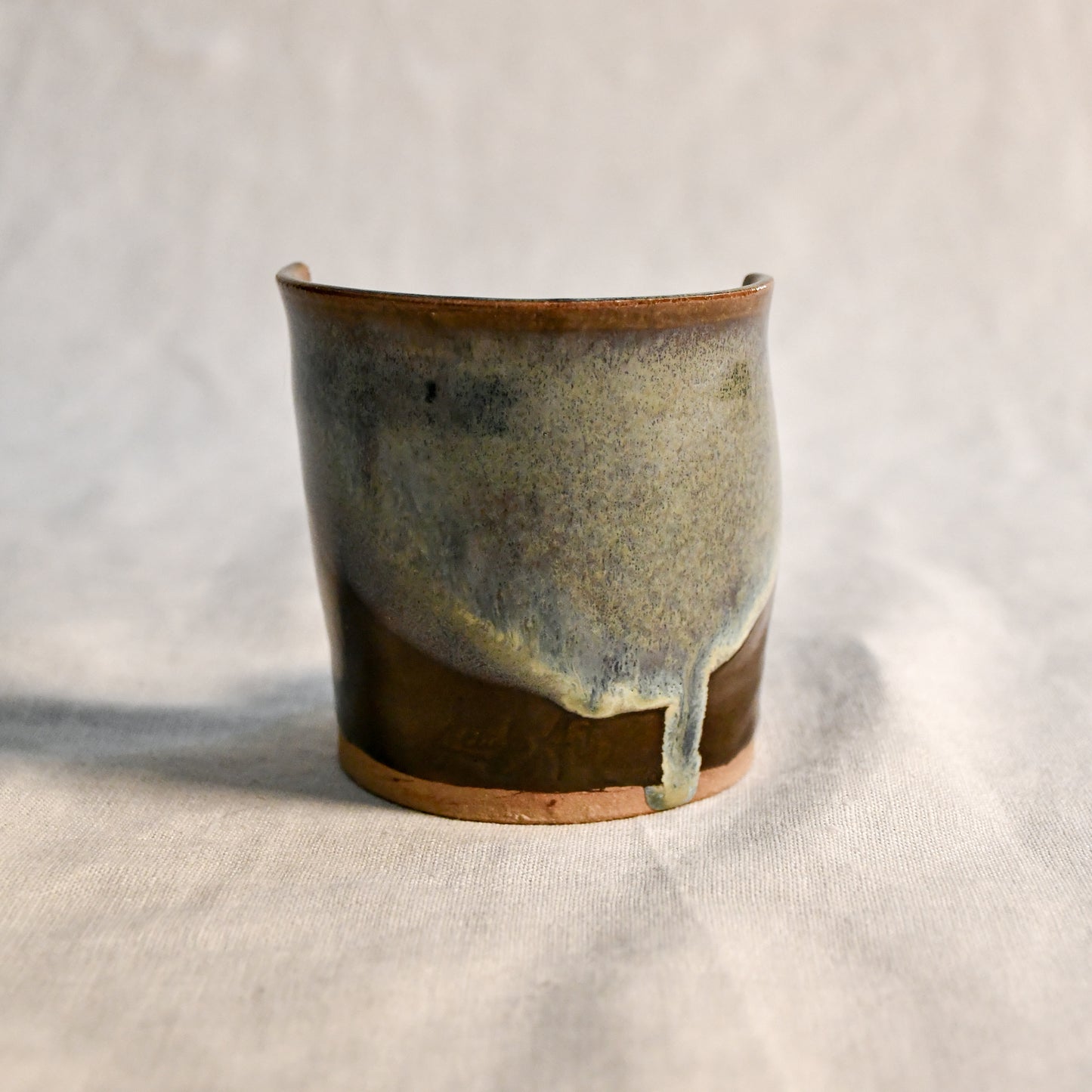 Handmade Espuela ceramic spoon rest by Leigh Art featuring layered earth-tone glaze with organic movement and one-of-a-kind variation.