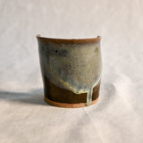 Handmade Espuela ceramic spoon rest by Leigh Art featuring layered earth-tone glaze with organic movement and one-of-a-kind variation.