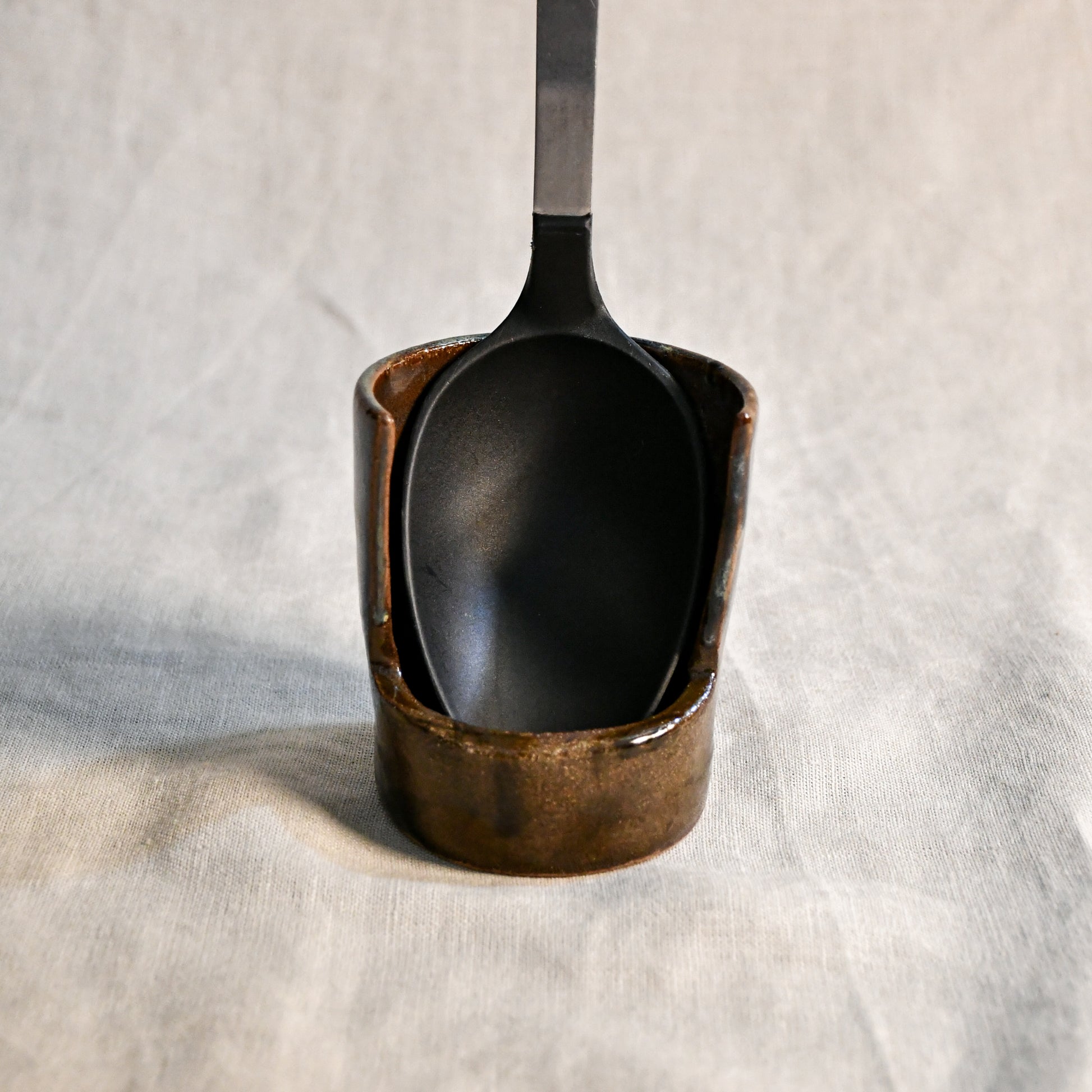 Handmade Espuela ceramic spoon rest by Leigh Art featuring layered earth-tone glaze with organic movement and one-of-a-kind variation.