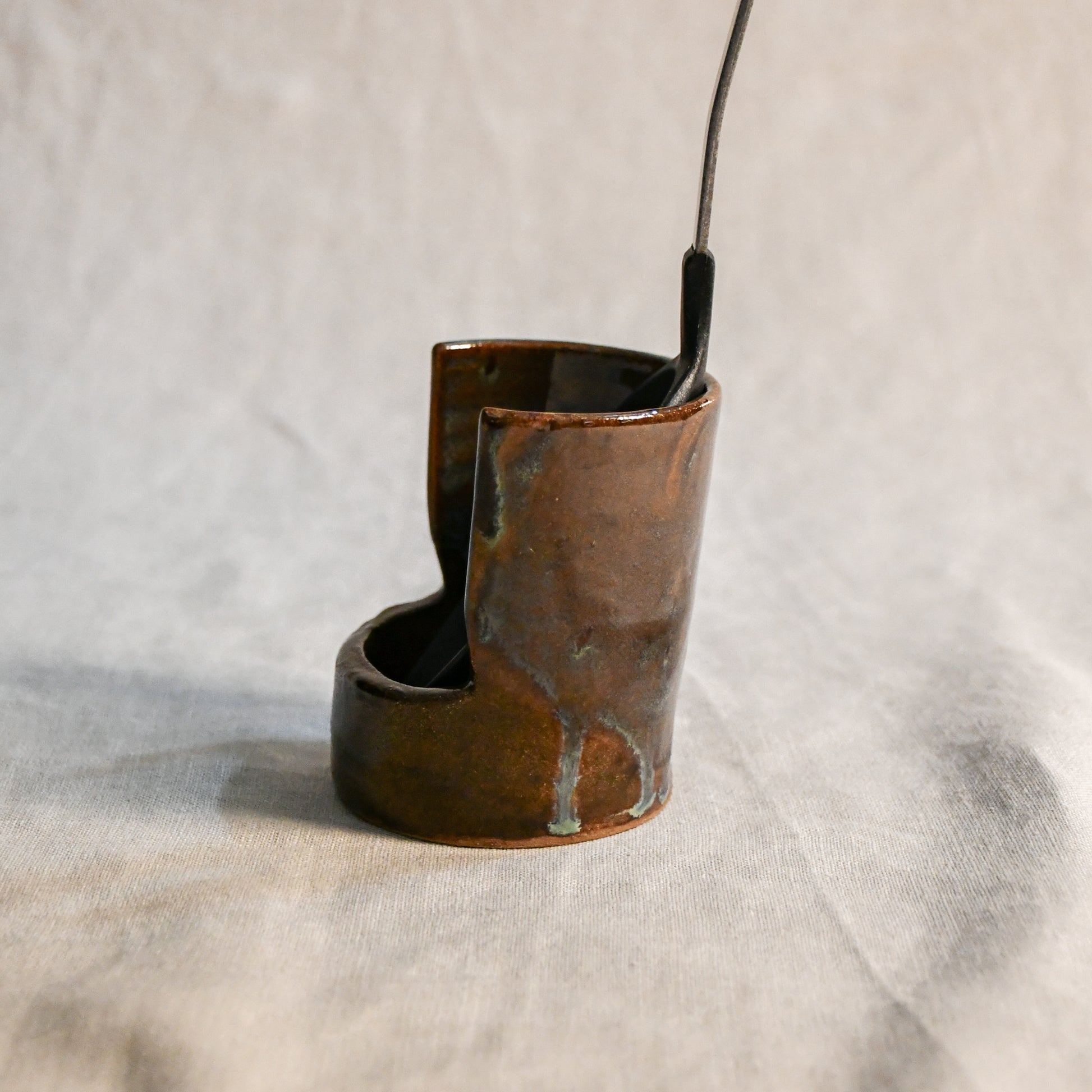 Handmade Espuela ceramic spoon rest by Leigh Art featuring layered earth-tone glaze with organic movement and one-of-a-kind variation.