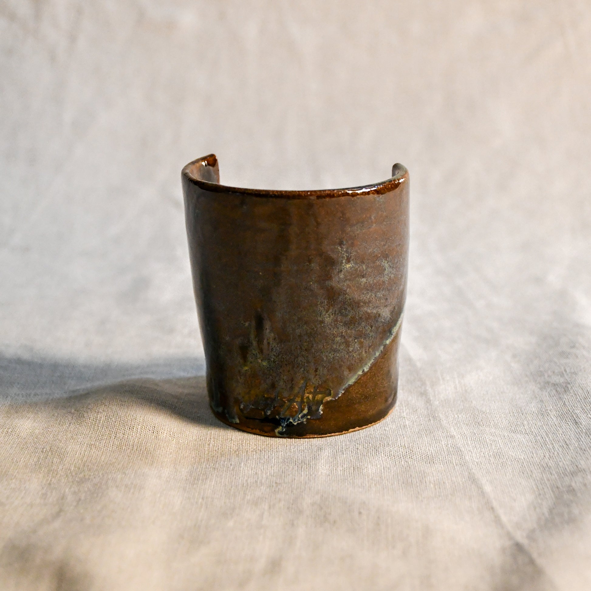 Handmade Espuela ceramic spoon rest by Leigh Art featuring layered earth-tone glaze with organic movement and one-of-a-kind variation.