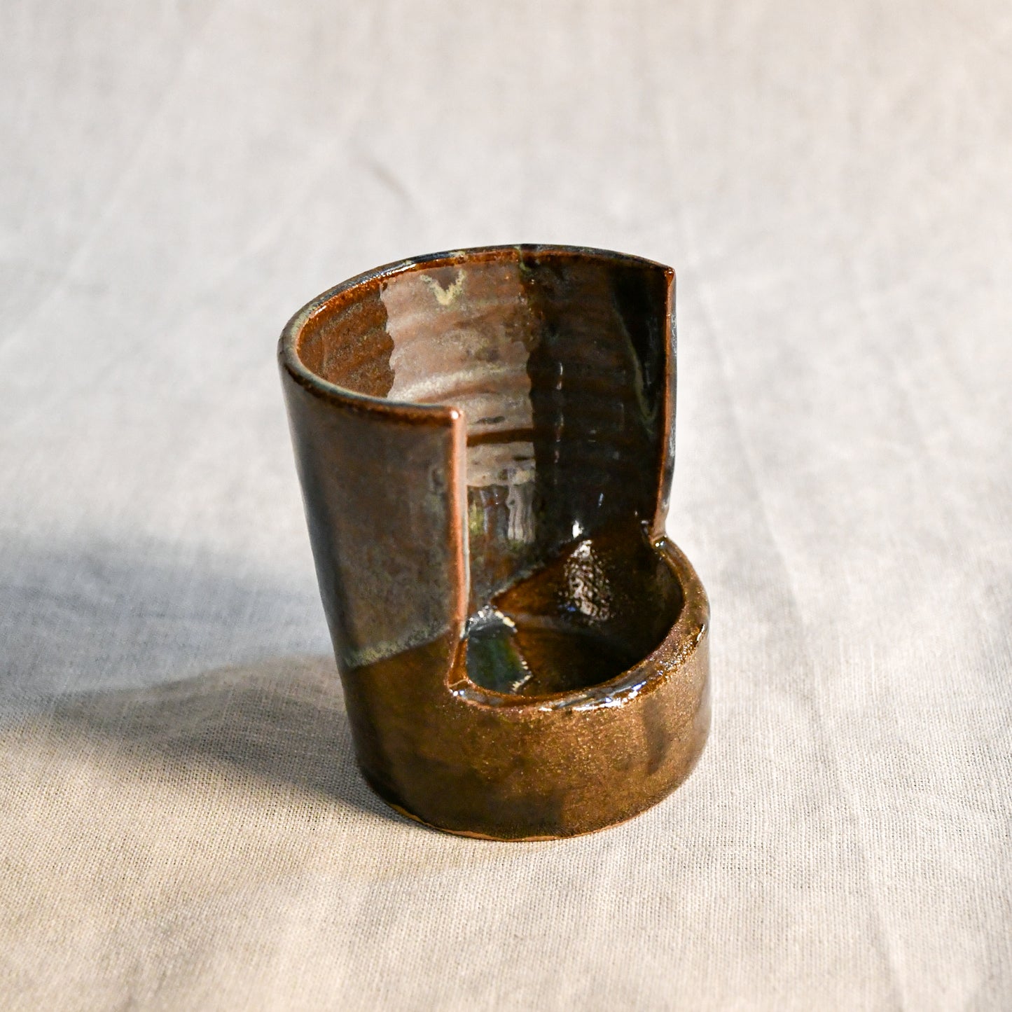 Handmade Espuela ceramic spoon rest by Leigh Art featuring layered earth-tone glaze with organic movement and one-of-a-kind variation.