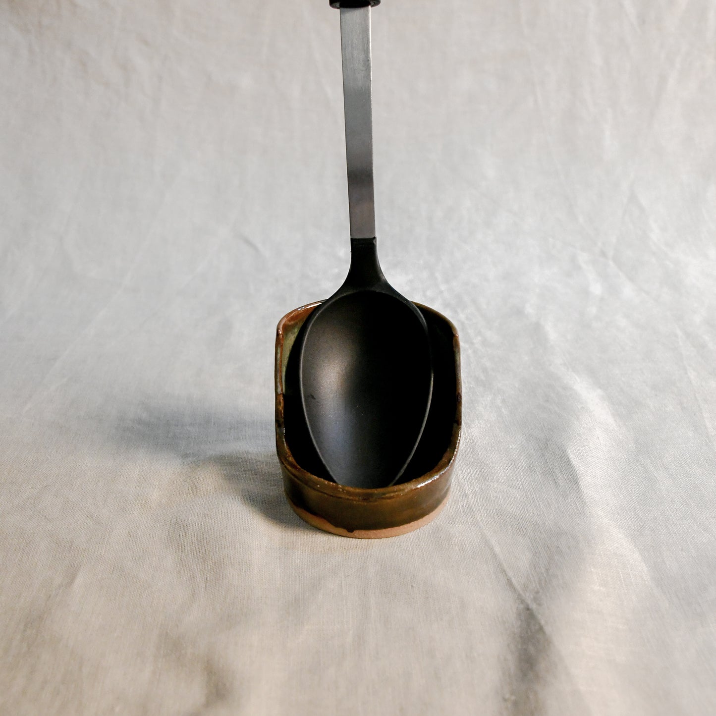 Handmade Espuela ceramic spoon rest by Leigh Art featuring layered earth-tone glaze with organic movement and one-of-a-kind variation.