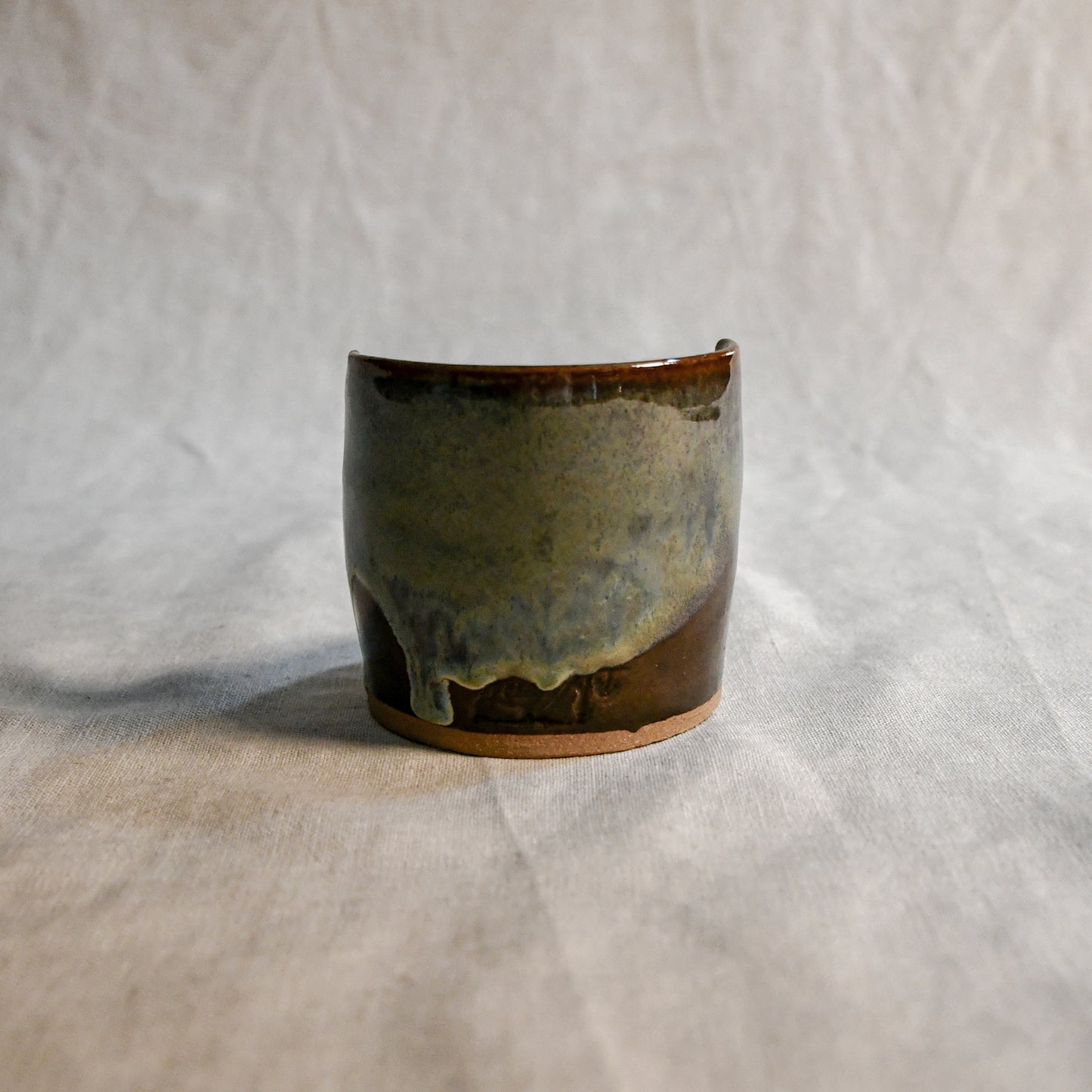 Handmade Espuela ceramic spoon rest by Leigh Art featuring layered earth-tone glaze with organic movement and one-of-a-kind variation.
