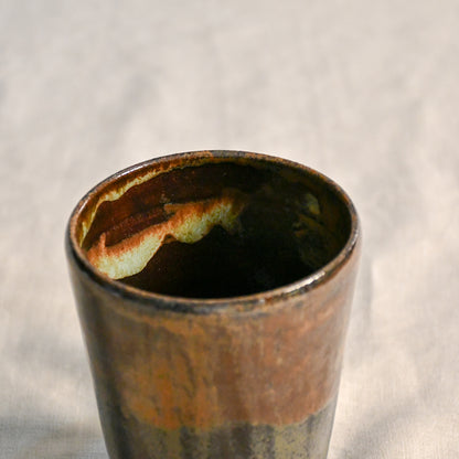 Close-up of the Ancient Jasper glaze inside a handmade stoneware mug, revealing ember orange and smoky black variations around the rim.