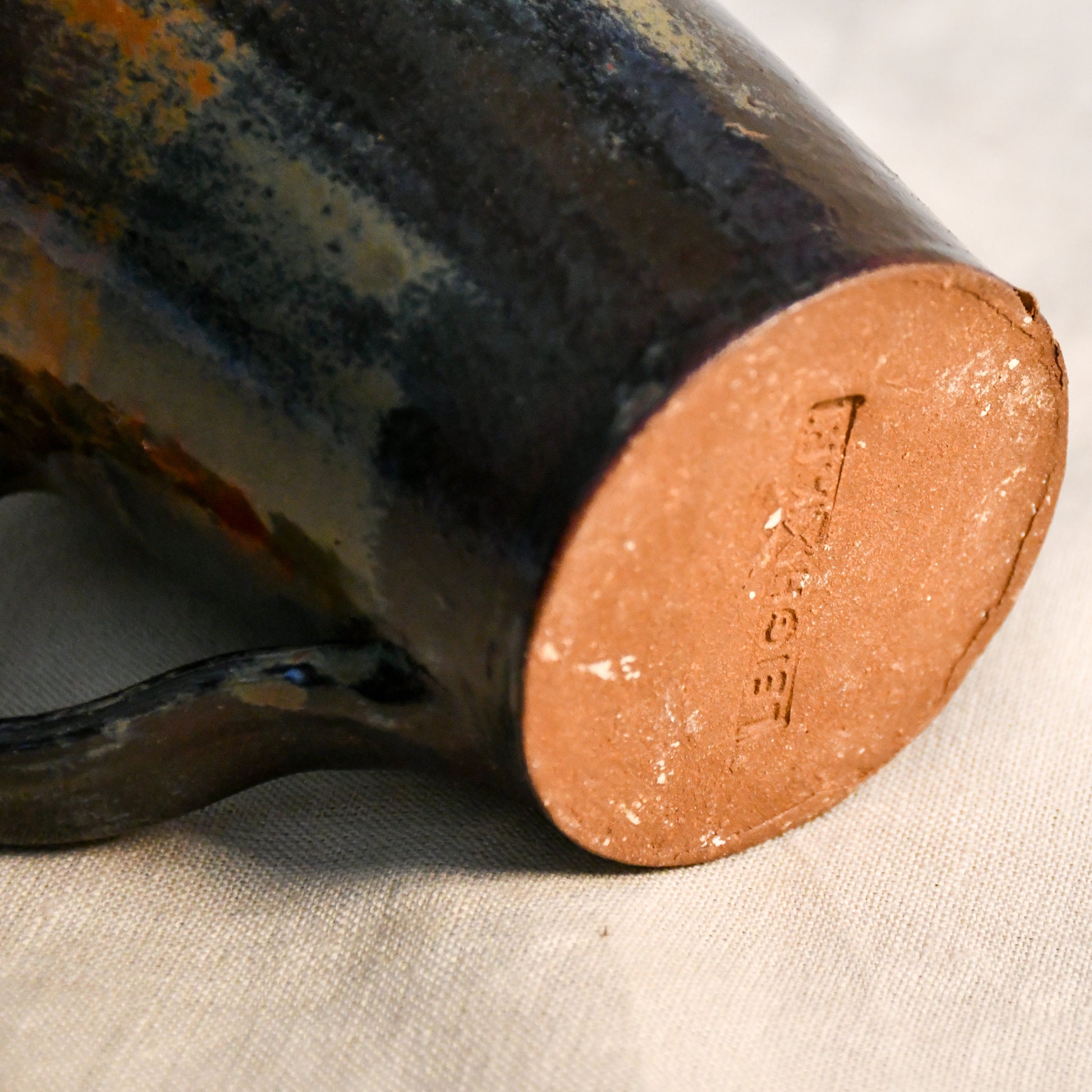 Detailed view of the Ancient Jasper glaze on a handcrafted ceramic mug, showcasing organic rust, olive, charcoal, and brown textures.