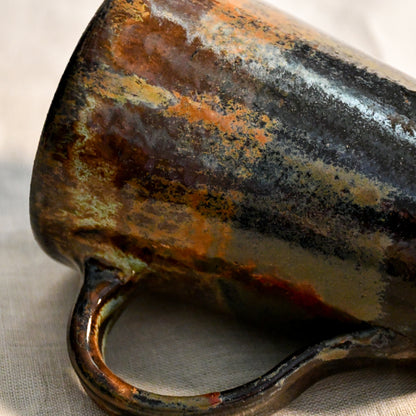 Detailed view of the Ancient Jasper glaze on a handcrafted ceramic mug, showcasing organic rust, olive, charcoal, and brown textures.