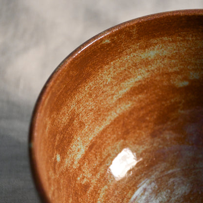 Close-up of the Heirloom Blue glaze inside a handmade ceramic chili bowl, showcasing layered rust, chestnut, and blue-green variation created during firing.