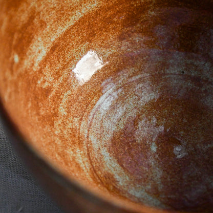 Close-up of the Heirloom Blue glaze inside a handmade ceramic chili bowl, showcasing layered rust, chestnut, and blue-green variation created during firing.