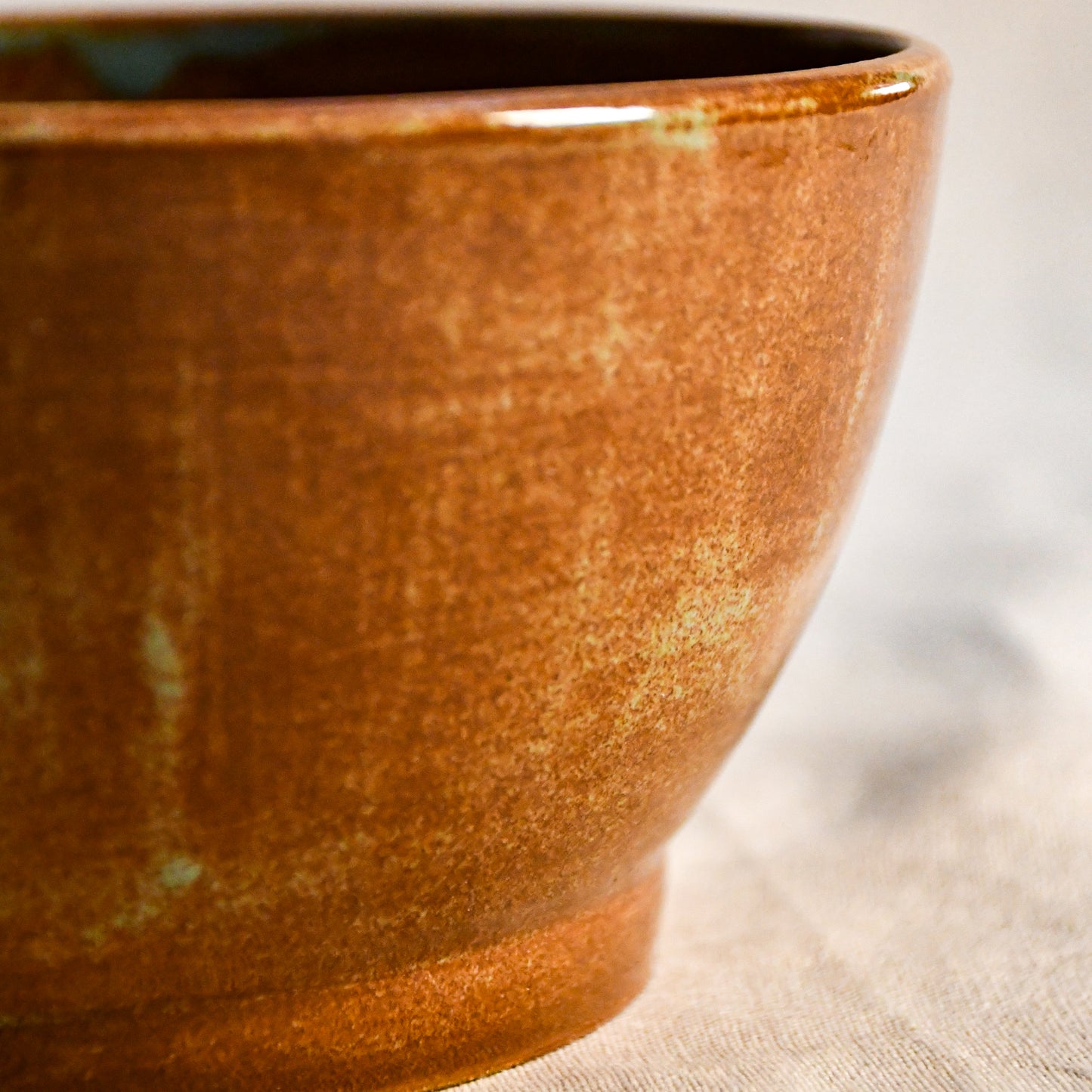 Detailed view of the Heirloom Blue glaze on a handcrafted stoneware bowl with earthy rust coloring and subtle blue breaks.
