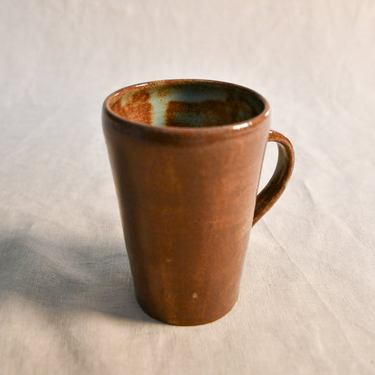 Detailed view of the Heirloom Blue glaze inside a wheel-thrown pottery mug, highlighting organic blue-green pooling and earthy brown speckling.