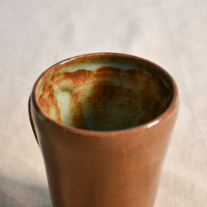 Detailed view of the Heirloom Blue glaze inside a wheel-thrown pottery mug, highlighting organic blue-green pooling and earthy brown speckling.