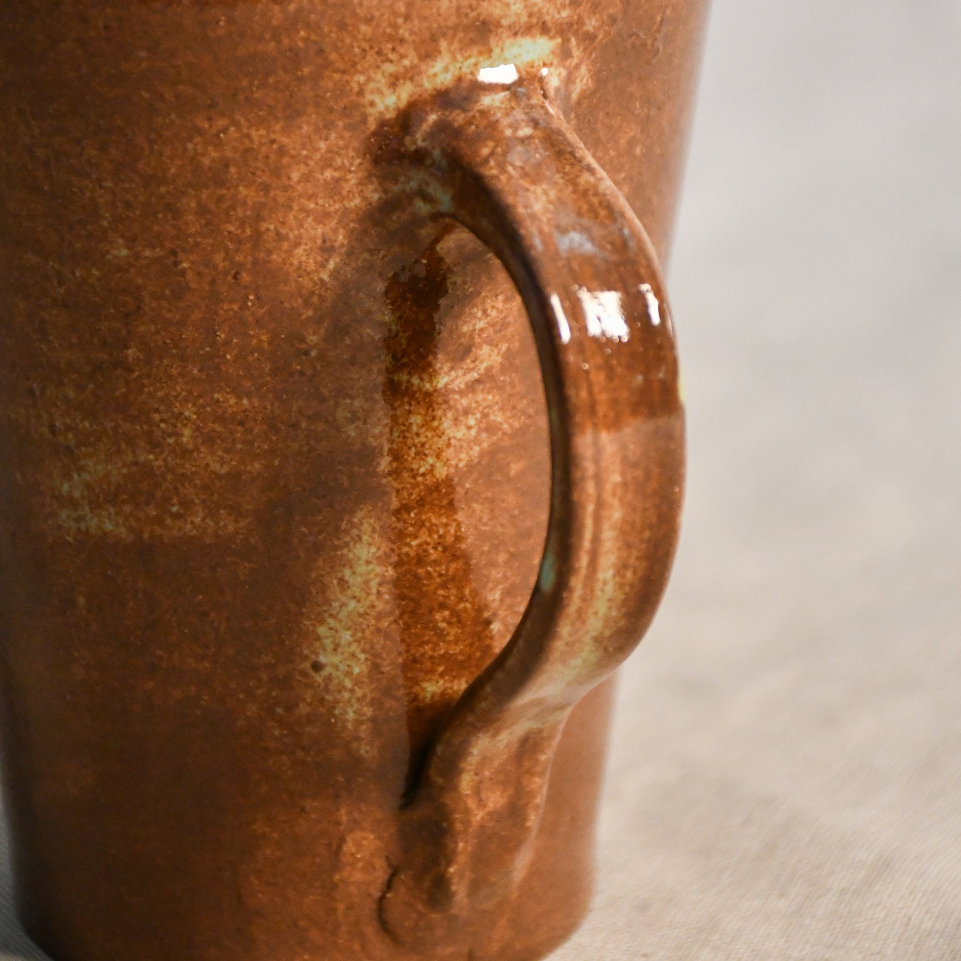 Close-up of the hand-pulled handle on a handmade ceramic mug finished in Heirloom Blue glaze with natural color variation.