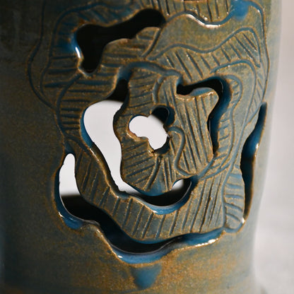 Close up of wheelthrown ceramic lantern, hand carved Peony design and glazed in turquoise. 