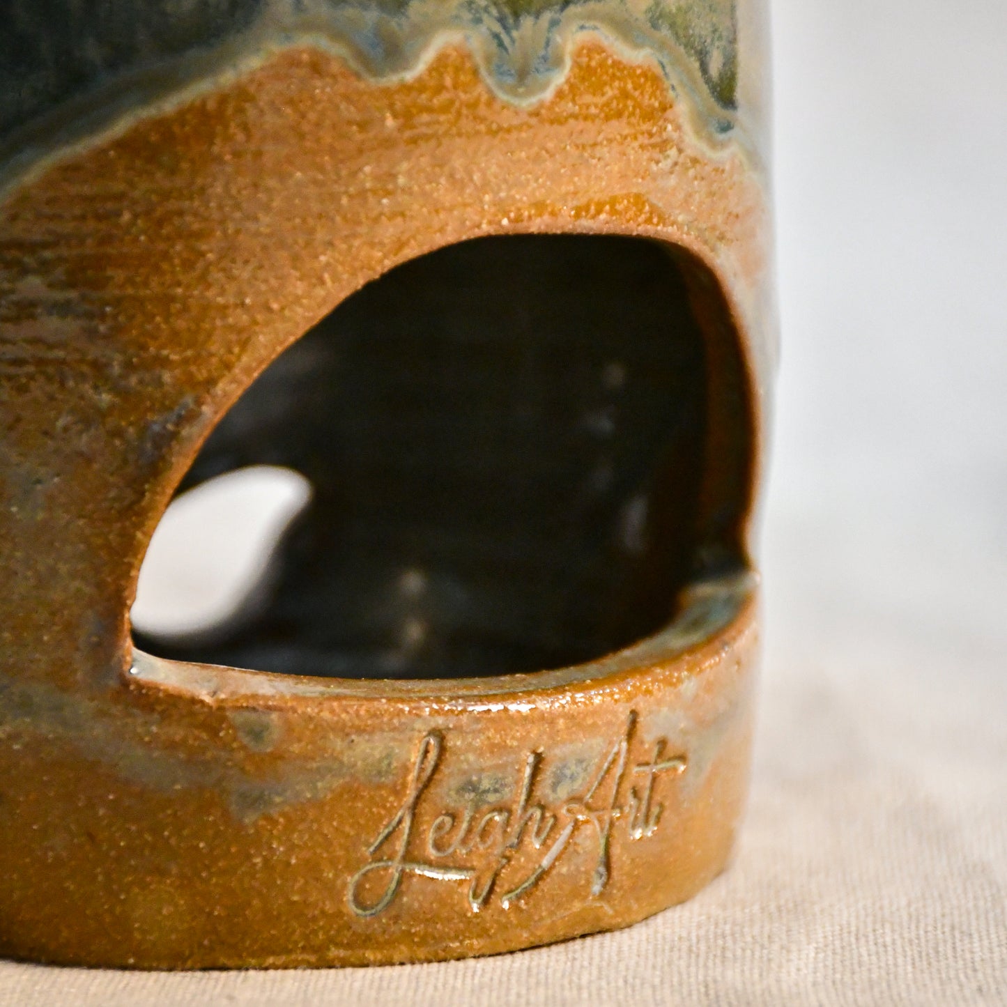 Close up of wheel thrown ceramic lantern, hand carved Peony design and glazed in Gun Metal Green. 