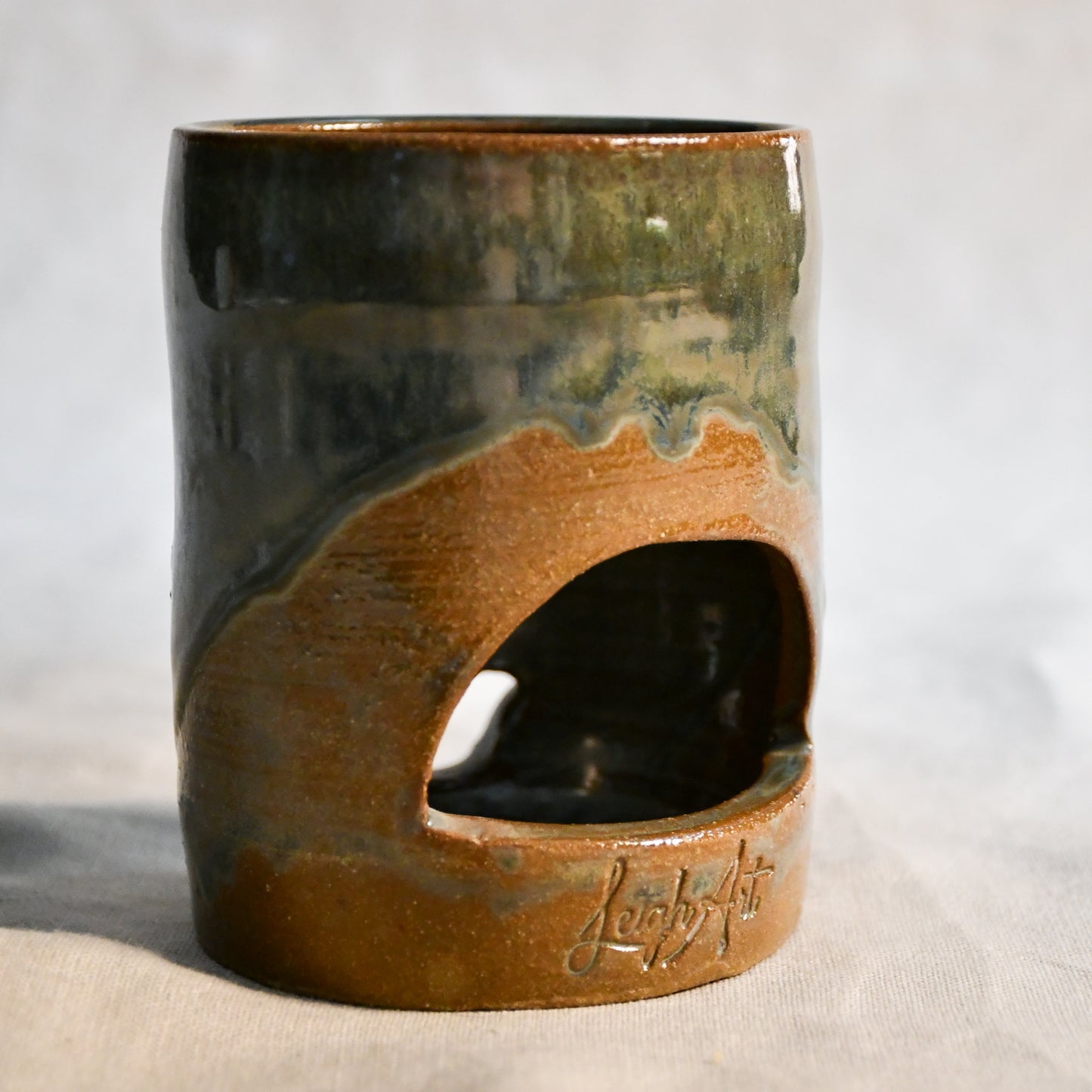 Close up of wheel thrown ceramic lantern, hand carved Peony design and glazed in Gun Metal Green. 