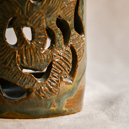 Close up of wheel thrown ceramic lantern, hand carved Peony design and glazed in Gun Metal Green. 