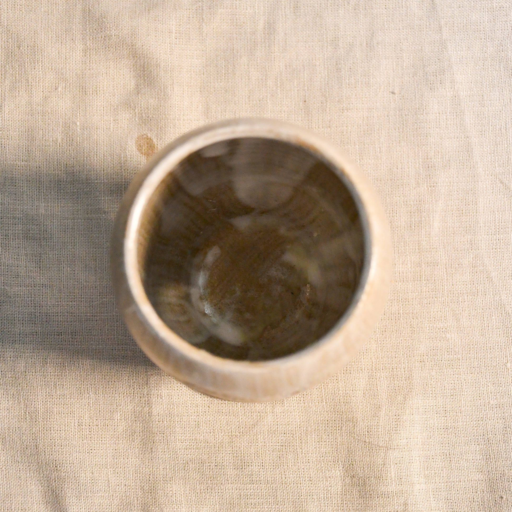 Top view of a white handmade wheel thrown, hand carved Peony design lantern fit for a tea light. 