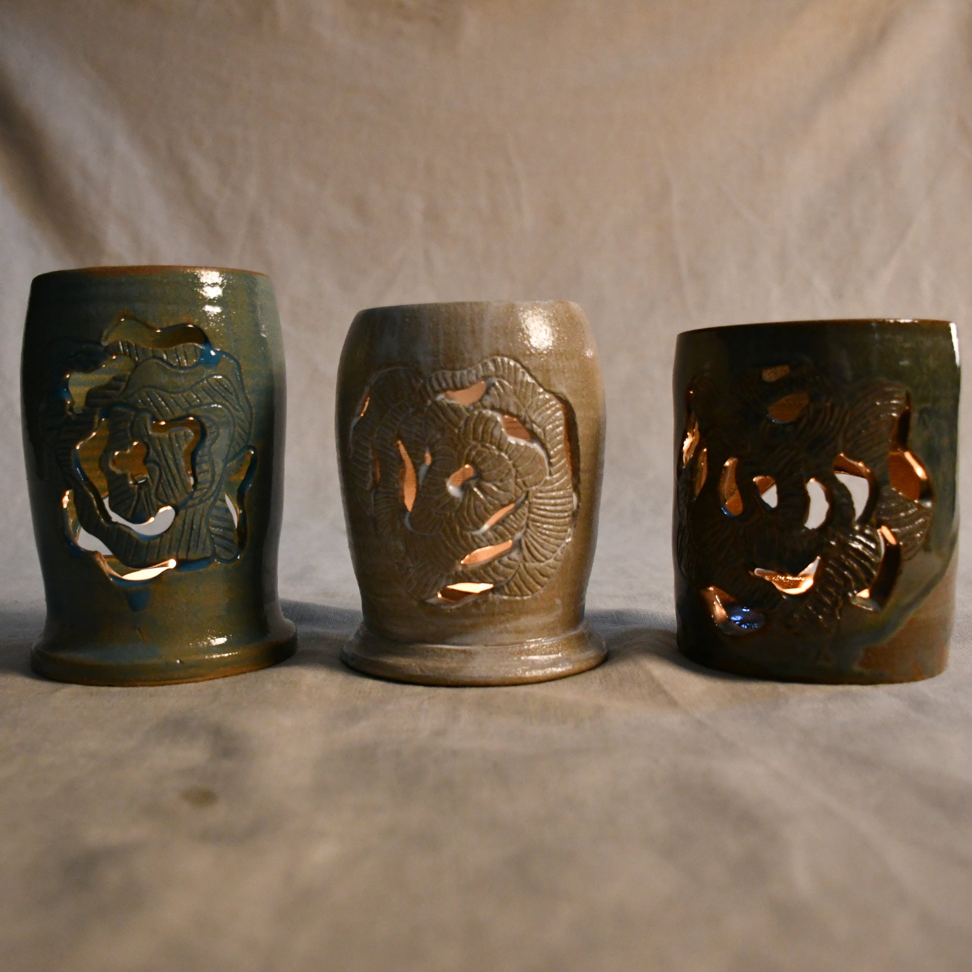 Lit handmade, wheel thrown, ceramic lanterns with hand carved Peony design. 
