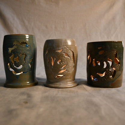 Lit handmade, wheel thrown, ceramic lanterns with hand carved Peony design. 