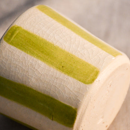 Detail of the lime striped mini mug featuring hand-painted stripes and fine crazing beneath the glossy clear glaze.
