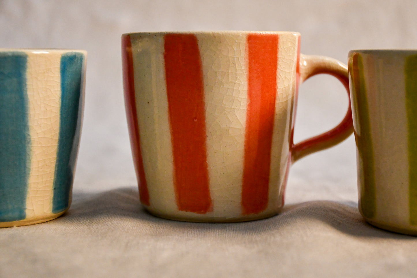 Handmade Striped Trio mini espresso mugs by Leigh Art featuring turquoise, lime, and coral hand-painted stripes with vintage-inspired crackled clear glaze from the Clayground collection.